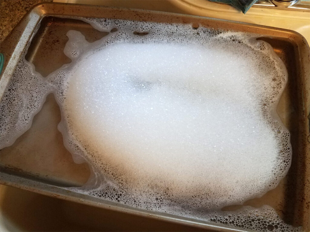 Alu Backblech einweichen mit Wasser und Spülmittel