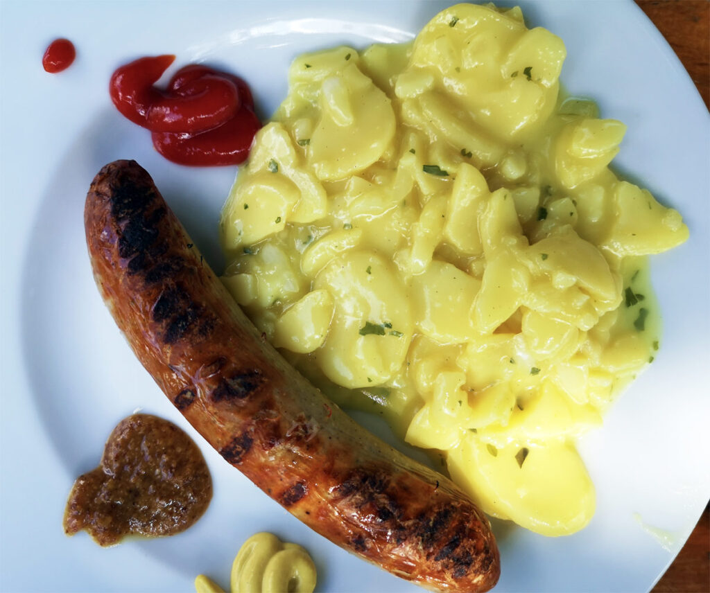 Ein Teller mit Bratwurst und Kartoffelsalat