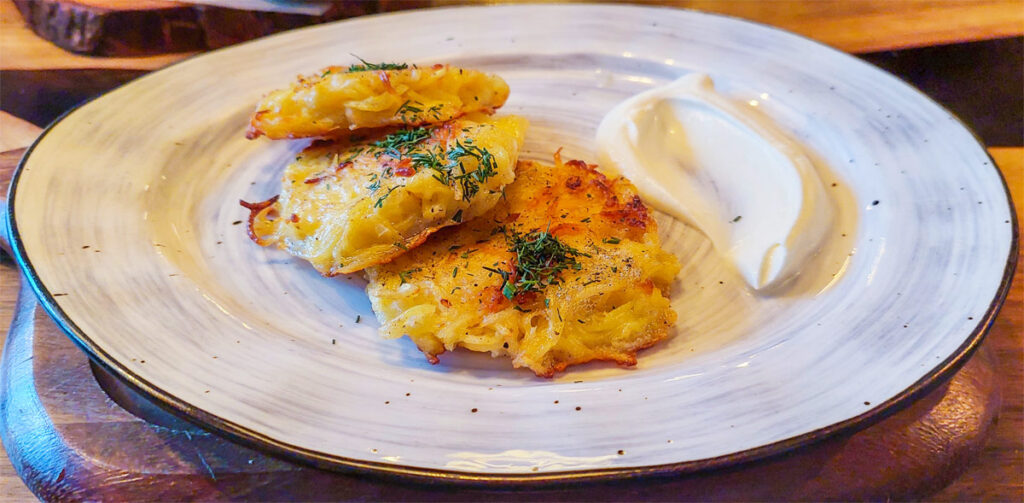Kartoffelpuffer mit saurer Sahne auf einem Teller