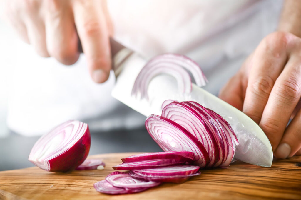 Zwiebelringe mit einem Messer schneiden
