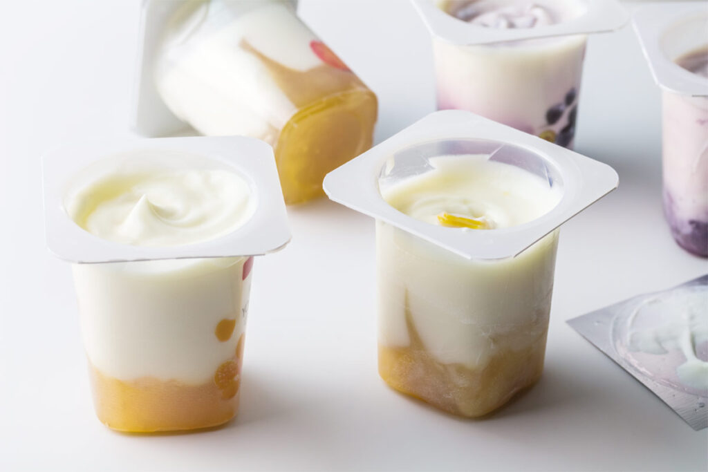 Zwei offene Becher mit Joghurt