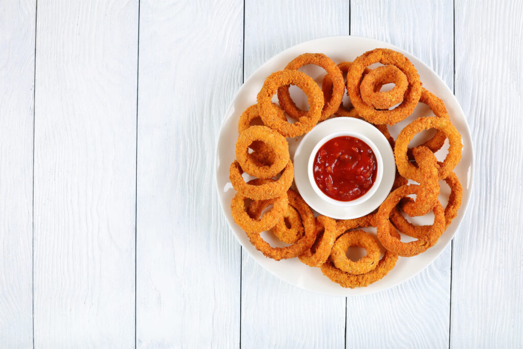 Teller mit Onion Rings und Ketchup