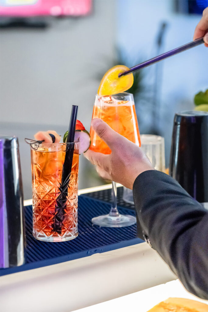 Aperol Spritz zubereiten in einem Cocktailglas.