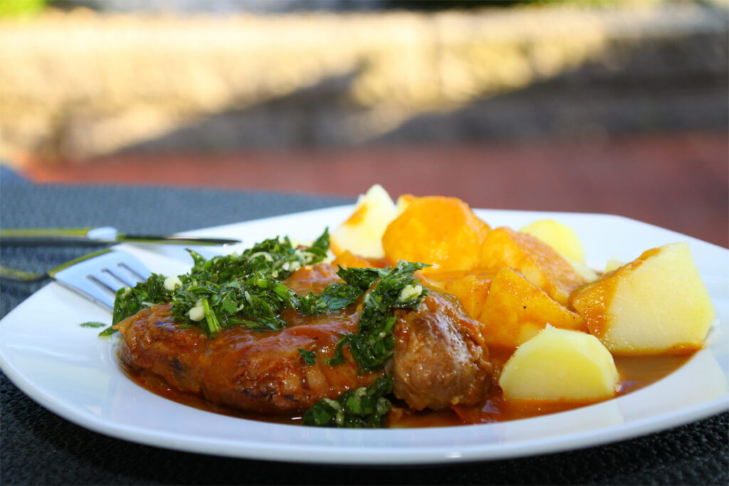 Ein angerichteter Teller mit Ossobuco und Kartoffeln.