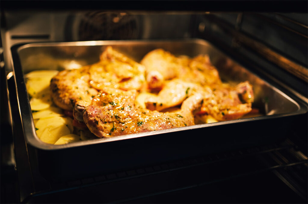 Im Ofen Hähnchenbrust mit Kartoffeln werden gar.