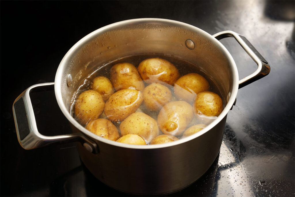 Pellkartoffeln kochen in einem Topf auf dem Herd