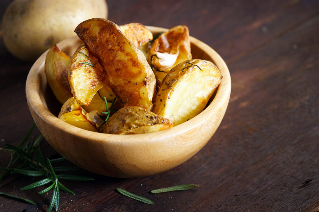 Eine Holzschale mit griechischen Kartoffeln.